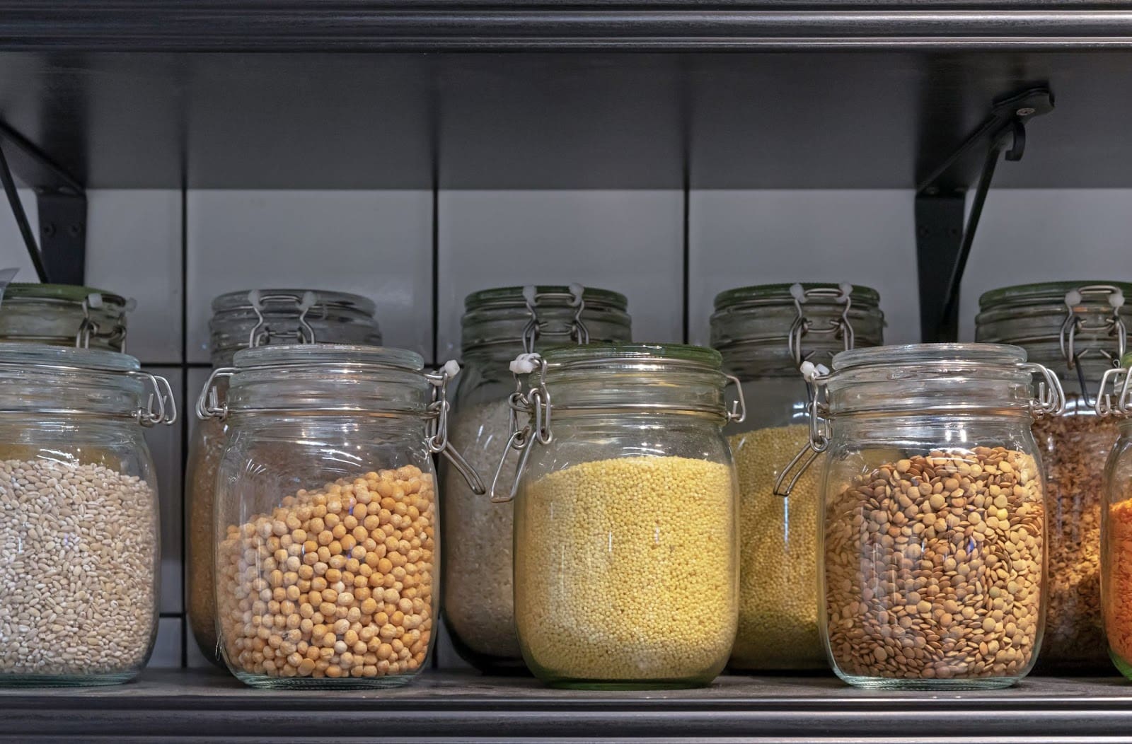 a shelf filled with jars filled with different types of food